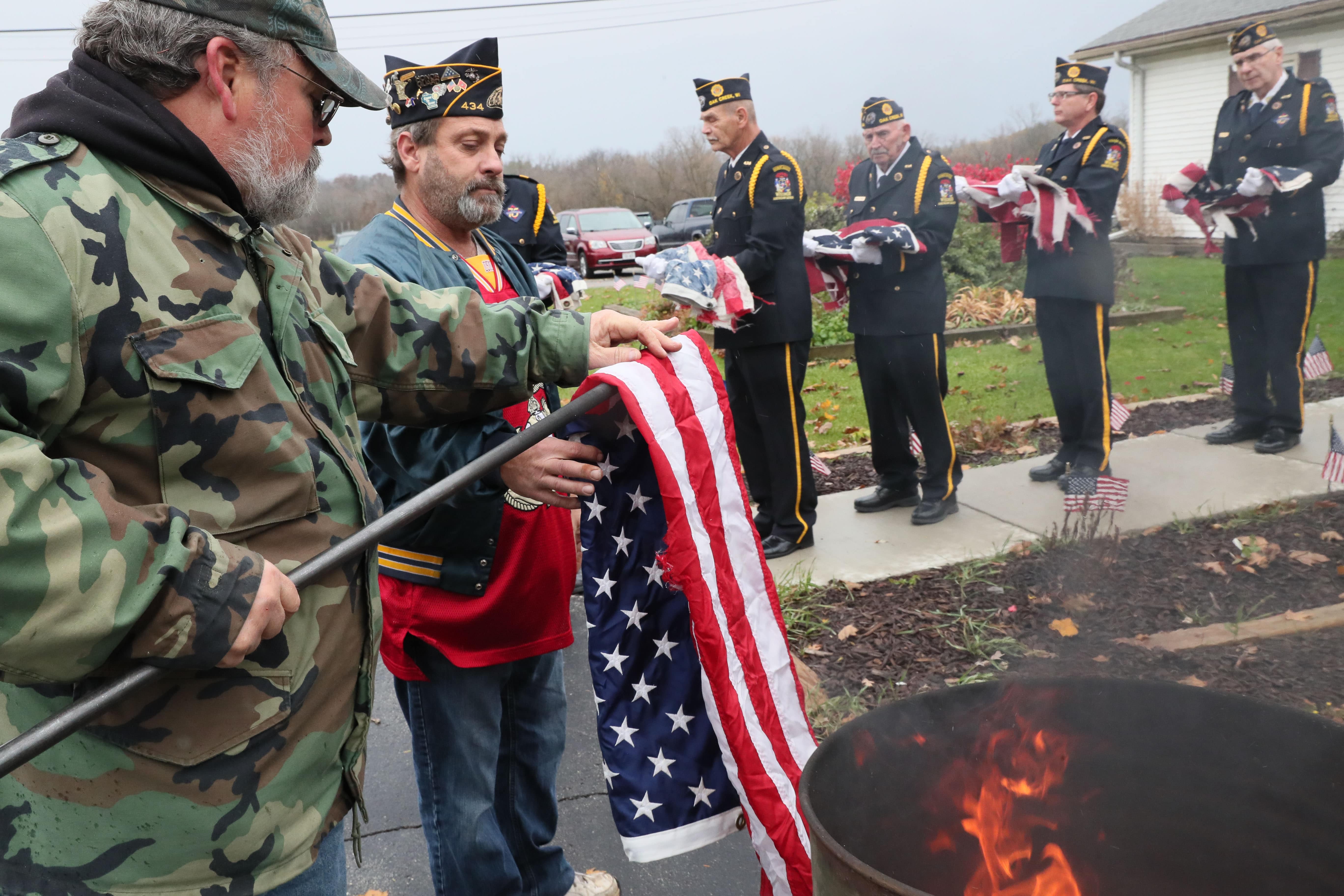 Here Roger Jenson (left) takes flags from Second Vice Commander Scott Zalewski (center) to be placed in the burn barrel. Other members of the honor guard wait at right with flags to be destroyed.

Photo by Michael Sears/Milwaukee Journal Sentinel