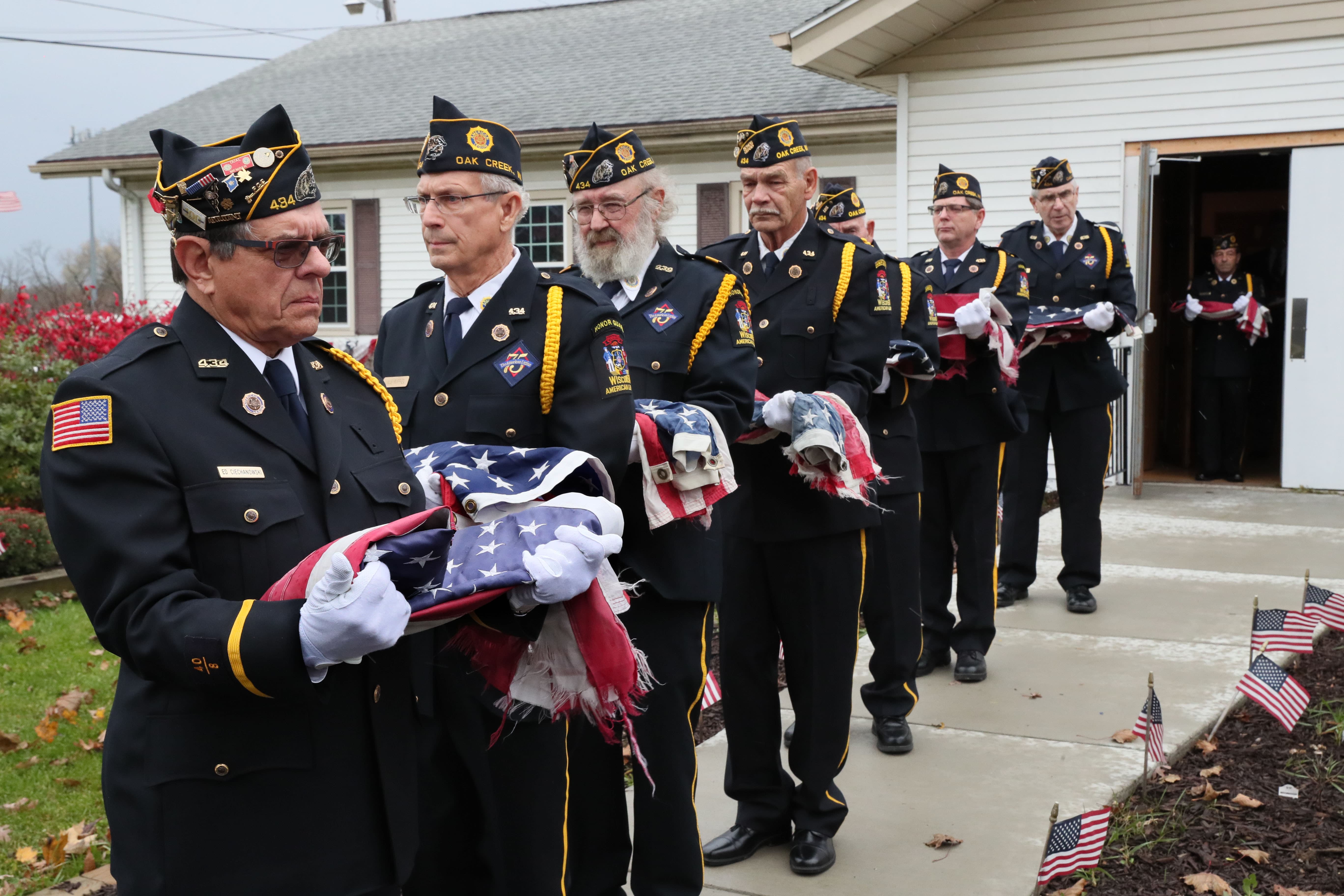 Here Ed Ciechanowski (far left) a member of the honor guard, holds a flag along with others as they make their way toward a fire where the flags will be destroyed.

Photo by Michael Sears/Milwaukee Journal Sentinel