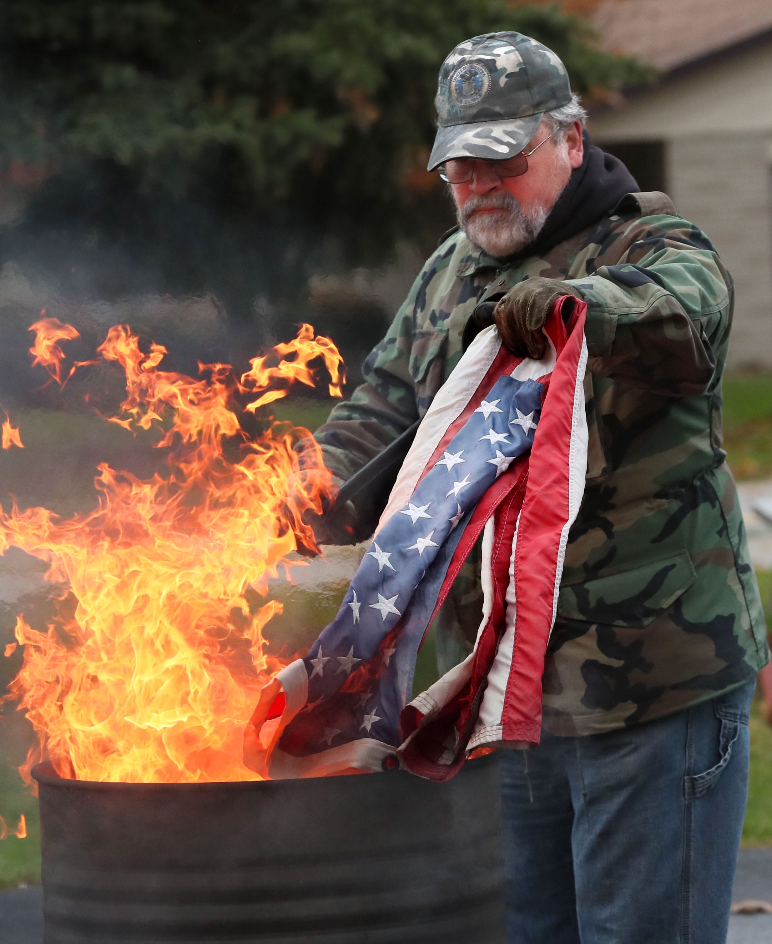 Here post member Roger Jenson, lowers a flag to be destroyed into the flames.
Photo by Michael Sears/Milwaukee Journal Sentinel