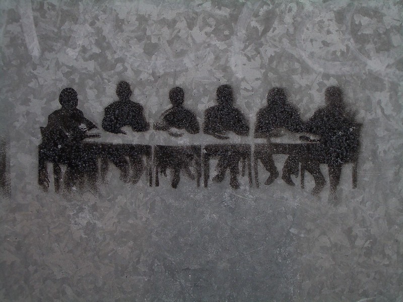 People seated at a meeting room table stencil.